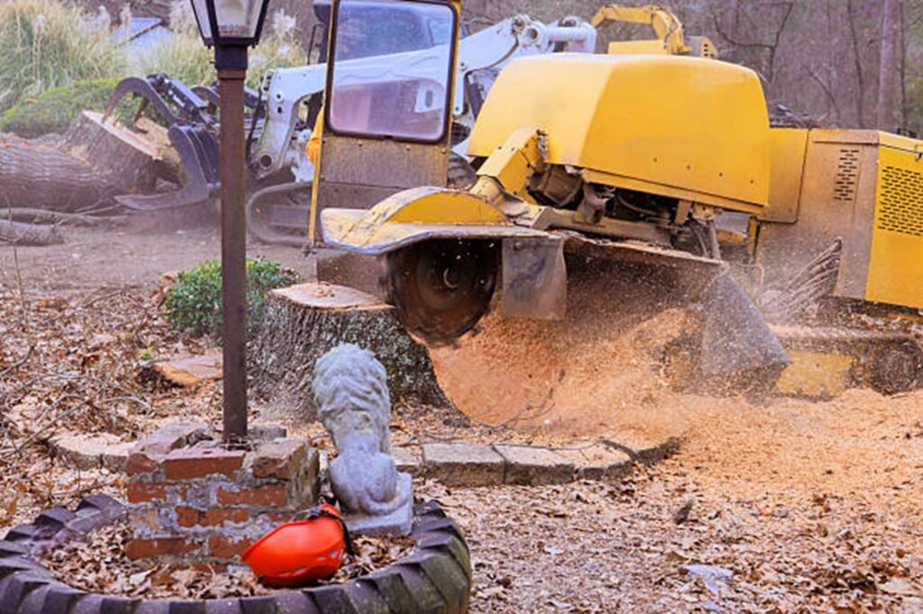 Stump grinding machine removing a large tree stump and wood debris in a residential yard in Cuyahoga Falls, OH