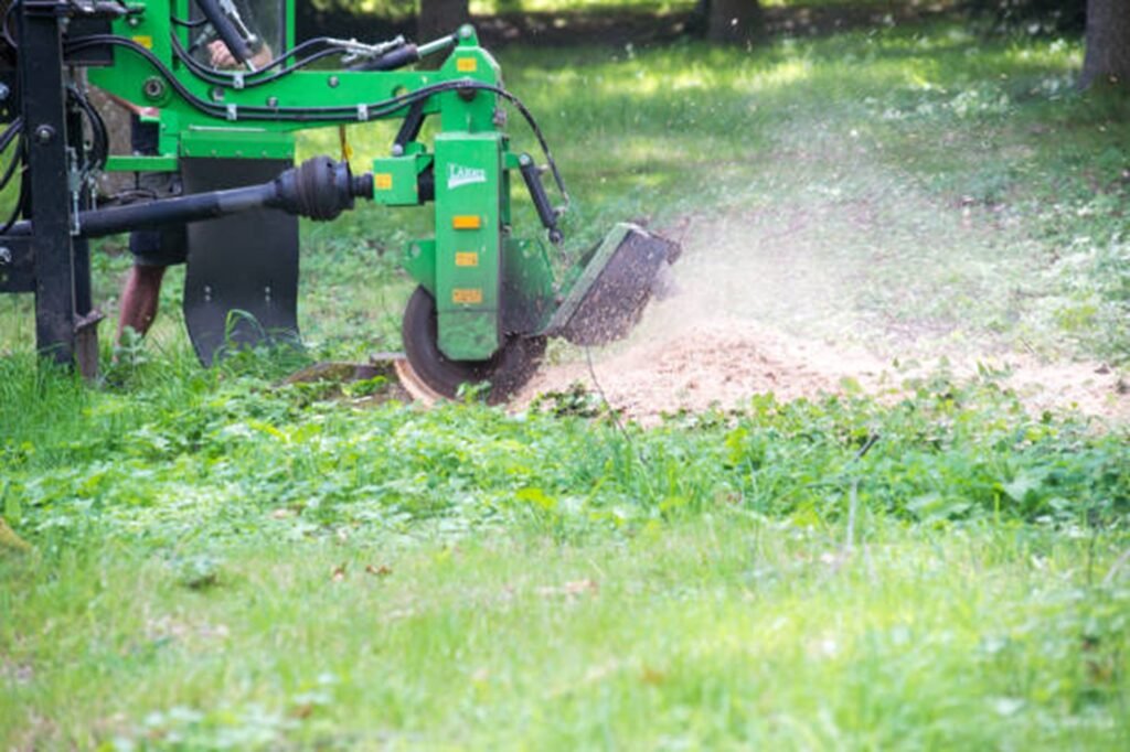 Stump grinding machine removing a tree stump and wood chips in a residential yard in Cuyahoga Falls, OH